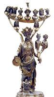 STE-4062 - Statuette : TutelaargentDéesse féminine debout, à coiffure crénelée, tenant une patère à droite et à guache deux cornes d'abondance terminées par des bustes; elles est surmontée d'une sorte de râtelier supportant 9 bustes divins.