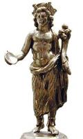 STE-4063 - Statuette : PénatesargentDieu masculin juvénile, torse nu, vêtu d'un manteau couvrant le bas du corps et retombant sur l'épaule gauche, coiffé d'une couronne à tourelles; il tend une patère de la main droite et porte une corne d'abondance au creux du bras gauche.