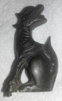 APP-7001 - Applique : dragonbronzeApplique en forme de dragon assis vers la gauche, la tête retournée en arrière, gueule ouverte; piton de fixation sous les pattes avant.