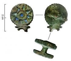 APT-4036 - Applique à tenons en T, type B11bronzeApplique pourvue au revers de 2 tenons en T, normalement guillochés sur la partie extérieure de la barrette ; l'objet est percé transversalement et un anneau retenu par un crampon replié à l'arrière y joue librement. Ce type présente une forme symétrique autour de l'anneau central, avec des extrémités formées de deux disques d'émail organisés en logettes rayonnantes.