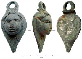 BAS-4041 - Attache d'anse de bassinbronzeAttache foliacée, en forme de visage enfantin, en fort relief, posé sur une feuille; au sommet, anneau d'articulation pour le crochet d'une anse mobile; au revers, décrochement destiné à caler l'objet au bord de la vasque (brasure).