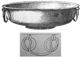 BAS-5002 - BassinbronzeBassin à marli horizontal, fond annulaire ; deux anses opposées (très simples, en oméga) sont fixées sur la panse à l'aide d'appliques brasées, en forme d'anneau terminé par un crochet.