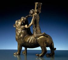 CHL-6006 - Chandelier zoomorphe : lion et hommebronzeUn lion debout, la tête retournée en arrière, supporte un homme (Hercule ?), agenouillé sur son dos, qui lui ouvre la gueule à mains nues. De ses épaules émerge la bobèche d'un chandelier, le tout coulé d'un seul tenant.