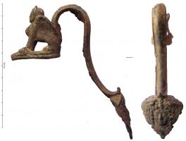 CRU-3010 - CruchebronzeCruche à embouchure étroite, dont l'anse épouse la lèvre. L'anse surélevée possède une applique inférieure soignée, avec une tête de face (dionysiaque, coiffée de fruits; ou tête de Méduse) ; au sommet, elle se termine par une sphynge assise.