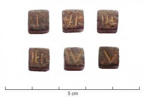 DEJ-4004 - Dé inscrit (nombres)bronzeTPQ : 300 - TAQ : 400Dé massif et cubique, sur lequel les marquage de points habituels sont remplacés par des chiffres et nombres romains incisés.