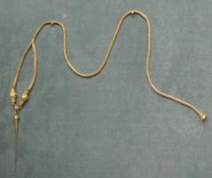 EPG-2029 - Épingle et chaîneorEpingle coute, à tête hémisphérique surmontée d'un anneau, auquel se rattache une chaînette tressée dont les deux brins se regroupent en une seule chaîne terminée par un ornement à granulations. 