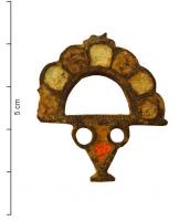 FIB-41004 - Fibule émailléebronzeFibule constituée d'un demi-cercle ajouré, formé d'une juxtaposition de loges émaillées à bordure externe festonnée, sous lequel apparaît un motif (également émaillé) en forme de cruche ou d'amphore à deux anses.