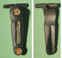 FIB-41486 - Fibule émailléebronzeFibule à charnière, arc court et rubanné, orné d'un cabochon d'émail ; pied creusé d'une gorge également émaillée, avec un autre cabochon émaillé sur le pied.