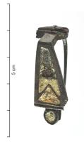 FIB-41894 - Fibule émailléebronzeFibule à arc non interrompu coudé à la tête, creusé de deux grandes loges d'émail avec une partie triangulaire vers le pied, orné d'un disque émaillé. 
