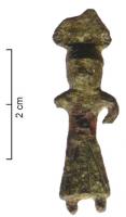 FIB-4585 - Fibule anthropomorphebronzeTPQ : 50 - TAQ : 250Personnage féminin debout, de face, vêtu d'une longue robe retombant jusqu'aux chevilles, les bras le long du corps. Sur une variante, le personnage est coiffé d'une feuille de lotus.