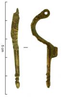FIB-5017 - Fibule wisigothique de type EstagelbronzeTPQ : 500 - TAQ : 600Fibule à pied rectiligne, un peu plus long que l'arc en demi-cercle; section ovalaire, parfois facettée; porte-ardillon court et rectangulaire, placé au sommet du pied; pied allongé et généralement terminé par un bouton; ressort en fer sur un axe passé dans la tête de l'arc.