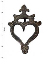 FIB-9129 - Broche : Sacré-Cœurbronze, ferBroche ajourée, peut-être en forme de cœur surmonté d'une flamme (Sacré Cœur). L'ardillon en fer passe dans une plaque perpendicuaire, et vient se fixer sur un porte-ardillon en forme de crochet.