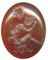 INT-4049 - Intaille : Satyre assispierre dureIntaille figurant un Satyre (sous la forme d'un jeune homme, avec une queue de cheval) assis, jouant de la syrinx ; à l'arrière-plan, parfois, chèvre couchée.
