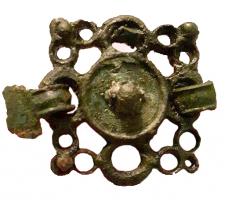 JHA-4065 - Jonction de harnaisbronzeJonction de harnais suspendue par quatre agrafes se croisant à angle droit; décor d'anneaux juxtaposés avec un disque central sans doute émaillé; boutons émaillés aux angles.