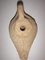 LMP-5088 - Lampe égyptienne tardive terre cuiteLampe en forme de goutte allongée. Disque décoré de cercles. Long bec avec croix et palmes. Argile noisette, engobe beige. Grande anse à l'arrière.
