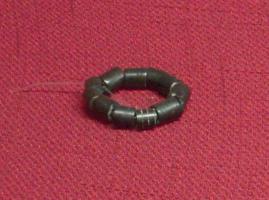 PRL-4014 - Perle cylindriquejaisTPQ : 200 - TAQ : 400Perle annulaire à cylindre tournée, avec une perforation axiale, souvent orné de gorges donnant l'impression d'une succession d'anneaux.