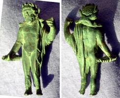 STE-4383 - Statuette : Jupiter - Zeus en majestébronzeTPQ : 100 - TAQ : 300Le dieu, figuré sous les traits d'un homme d'âge mûr, est debout, au repos, le bras droit le long du corps et la main tenant le foudre ou une patère, le bras gauche replié, appuyé au sceptre. Une chlamyde couvre le côté gauche et décrit une série de plis disposés régulièrement dont le bord forme une ligne sinueuse.