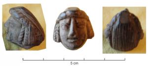 STE-4424 - Statuette ?bronzeTête séparée de son support, visage encadré de tresses verticales sur les côtés.