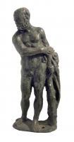 STE-9008 - Statuette : Héraklès - HerculebronzeAvançant la jambe gauche et le corps penché vers la droite, hercule saisit sa massue posée sur le sol à sa gauche; la peau du Lion de Némée pend à son avant-bras gauche.