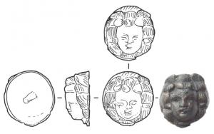 APM-4064 - Applique : tête de MénadebronzeTPQ : 1 - TAQ : 200Applique massive, sans fixation visible, faite en conséquence pour être fixée par brasure sur une surface métallique : braséro par exemple. Tête de jeune femme, aux cheveux encadrant symétriquement le visage (Ménade ?).