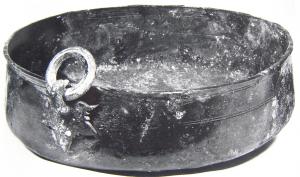 BAS-4003 - Bassin de type WehringenbronzeTPQ : 200 - TAQ : 325Bassin à panse cylindrique, équipé de trois anses pour suspension sur un trépied (type Wehringen) ; les attaches, fixées par brasure sur la paroi verticale du bassin, sont en forme de feuille de vigne, surmontées d'un fort crochet à tête de panthère ; sur ces crochets s'articulent de gros anneaux moulurés assurant la suspension de l'ensemble.