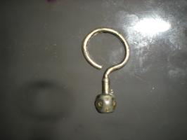 BCO-5002 - Boucle d'oreilleargent doréBouce constituée d'un simple fil, en crochet ouvert prolongé par une partie verticale (forme de ?) avec en guise de lest une perle marqué de cercles oculés sur quatre faces.