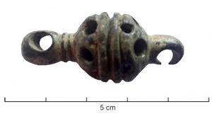 CHC-3012 - Maillon de chaîne-ceinturebronzeMaillon de chaîne-ceinture laténienne, comportant deux anneau plats, coulés, séparés par une perle cylindrique creusée d'une gorge médiane et ornée d'un semis de perforations.