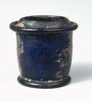 ENC-4010 - EncrierverreForme soufflée, corps cylindrique limité en haut et en bas par des bourrelets; au sommet, sorte de dôme aplati percé d'une ouverture centrale rétrécie ; un couvercle à sommet conique s'adapte dans cette ouverture pour la boucher hermétiquement.