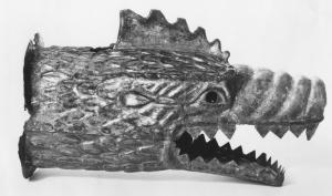 ENS-4003 - DracobronzeEmbouchure d'enseigne de cohorte romaine (draco) en tôle de bronze, figurant une tête de dragon, à la gueule ouverte et aux dents acérées, avec crête.