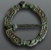 FER-7020 - Fermail inscritbronzeFermail annulaire plat, interrompu à deux reprises par des décors plastiques figurant des mains jointes; ardillon bloqué dans une encoche; legende moulée, généralement une invocation à Marie.