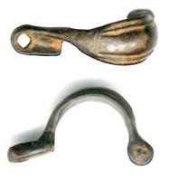 FIB-2076 - Fibule à pied rivetébronzeFibule à arc cintré, foliacé, marqué de deux paires de cannelures dégageant une zone médiane lisse ; pied percé d'un trou pour un ornement riveté perpendiculaire ; ressort monté sur un axe passé dans la tête perforée de l'arc.