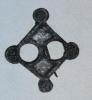FIB-41223 - Fibule symétrique émailléebronzeTPQ : 150 - TAQ : 300Fibule symétrique, à corps central losangique émaillé, percé de deux ajours circulaires; aux quatre coins, disques émaillés.