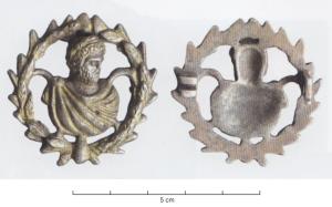 FIB-41914 - Fibule à buste : Caracalla, couronneargent doréBroche en forme de buste d'un homme barbu et lauré, drapé dans un manteau retenu sur l'épaule par une fibule, dans une couronne de lauriers ; revers creux sous le buste, charnière articulée sur deux plaquettes coulées.