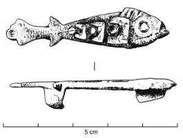 FIB-4622 - Fibule zoomorphe : poissonbronzeTPQ : 100 - TAQ : 260Fibule plate, le corps du poisson assez schématique est creusé d'une loges d'émail allongée, avec un cercle émaillé en réserve figurant l'œil sur la tête; les autres détails de l'animal sont suggérés par des incisions et ponctuations.