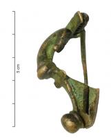 FIB-4807 - Fibule danubiennebronzeFibule coulée, à long ressort protégé par des plaquettes ; l'arc forme une double crosse à la tête, et se coude brutalement ensuite au niveau d'une nodosité ; le pied est terminé par un bouton rapporté ; porte-ardillon trapézoïdal massif.