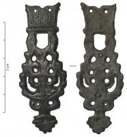 FRT-9008 - Ferret de ceinturebronzeFerret allongé et ajouré, aux bords festonnés, terminé par un motif en forme de fleur; le sommet, constitué d'une plaque percée de deux trous pour des rivets (deux autres s'alignent au centre du ferret) porte une lettre gothique hachurée (M, peut-être pour Maria)