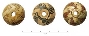 FUS-4013 - Fusaïole décoréeosTPQ : 300 - TAQ : 800Fusaïole tournée en os, profil en calotte de sphère, base plane; décor de traits et cercles oculés dessinant 4 ou 5 oiseaux (les creux peuvent être remplis de matière noire ou rouge).