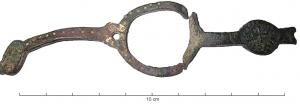 IND-6006 - Armature à décor monétiformebronze doréObjet avec motifs monétiformes de deniers languedociens des XIIe-XIIIe s., disposés sur une bande plate interrompue par un large anneau plat.
