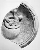 LMP-42635 - Lampe Loeschcke I : Diogèneterre cuiteLampe à large bec en enclume ; sur le médaillon, homme émergeant d'un pithos couché sur le côté ; auprès de lui, légende DIOGENE.