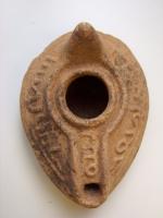 LMP-4670 - Lampe pantoufle byzantineterre cuiteLampe ovoïde à bec à canal incorporé. Epaule et canal décorée d'inscriptions arabes. Petite anse conique à l'arrière.