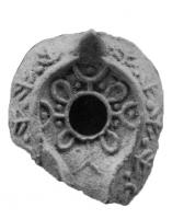 LMP-6084 - Lampe en forme d'amandeterre cuiteLampe en forme d'amande, anse en tenon conique, réservoir à trou central entouré d'une dépression qui rejoint le bec en formant un canal; décor d'arcs de cercles formant un motif géométrique sur le réservoir, et de palmes (ou conifères) sur l'épaule.