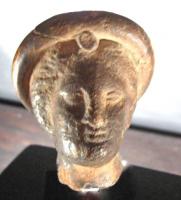 STE-3028 - Statuette tête féminineterre cuiteTête féminine coiffée d'un diadème ou d'une couronne, avec un médaillon au-dessus du front.