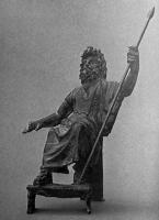 STE-4026 - Statuette : SarapisbronzeStatuette en bronze représentant Sarapis assis, trônant (petit taboutret sous les pieds), appuyé à gauche sur une lance, la main droite avancée et posée sur un objet (disparu).