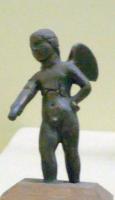 STE-4085 - Statuette : Eros - AmourbronzeAmour est figuré sous les traits d'un jeune garçon, nu et pourvu de deux ailes entre les épaules; penché en avant, la main gauche dans le dos, la droite portée devant lui, il participe sans doute à un groupe mythologique, ou à une scène de jeu.