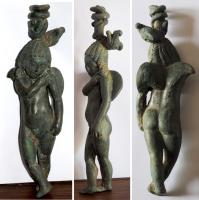 STE-4413 - Statuette : Eros / AmourbronzeEros ailé, sous la forme d'un jeune e, coiffure numide en côtes rayonnantes à partir du sommet du crâne, jambes croisées, la main droite posée sur l'épaule gauche; coiffure en forme de couronne égyptienne (Harpocrate ?)