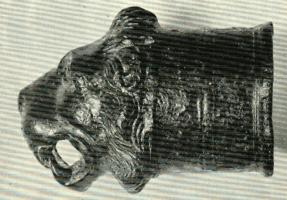 ACH-4028 - Extrémité de timonbronzeTPQ : 1 - TAQ : 100Gaine cylindrique décorée de filets parallèles dont la partie antérieure est modelée en protomé de lion rugissant.