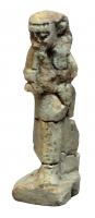 AML-2002 - Amulette anthropomorpheterre cuiteTPQ : -600 - TAQ : -500Amulette en fritte émaillée, représentant un berger debout, tenant un agneau (?) dans ses bras.