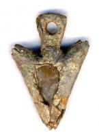 AML-4002 - Amulettebronze, pierreUne pointe de flèche préhistorique a été enrobée dans une feuille de bronze pour former un objet, lui-même en forme d'armature pédonculée, et percé d'un trou de suspension.
