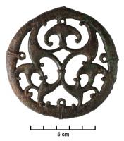 APH-4231 - Phalère de harnaisbronzeTPQ : 200 - TAQ : 300Disque dont le décor ajouré est constitué de trompettes recourbées. Quatre petits anneaux, disposés symétriquement, permettent la fixation de l'objet. Face avant en relief et arrière plat.