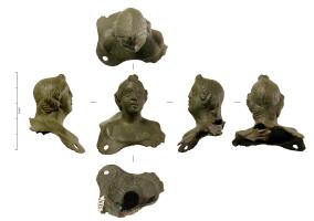 APM-4071 - Applique buste enfantin
bronze
Applique en forme de buste enfantin, aux traits quelque peu figés ; les épaules sont nues. L'applique était fixée par au moins deux trous au bas de la face antérieure et deux autres à l'arrière. La chevelure bien ordonnée avec un corymbe sur le haut du front et deux tresses roulées sur chaque oreille, qui sont masquées par la coiffure, se prolonge sur l'arrière, masquant la nuque.